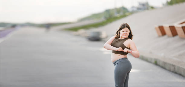 girl child teenager in sportswear with excess weight does exercises, plays sports outside in summer. - teen obesity imagens e fotografias de stock