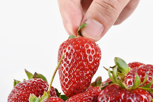 food photo a small amount of strawberry in hands on green background in summer day