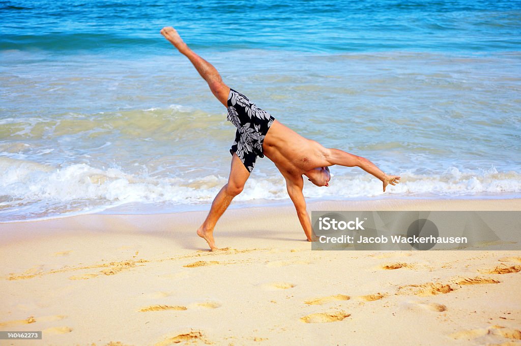 Homem fazendo cartwheels na areia - Foto de stock de Adulto royalty-free