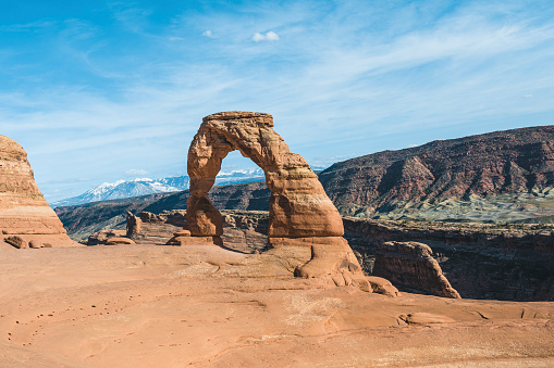 A woman walks through North Window Arch with Turret Arch in the background