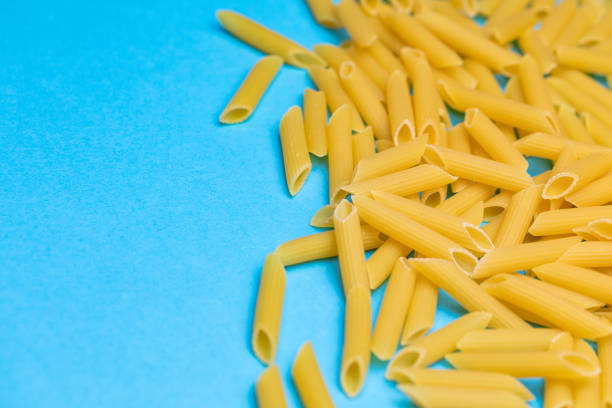 Raw pasta on blue background