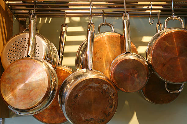 istock Several metal pots hanging from an overhead pot rack 140462634