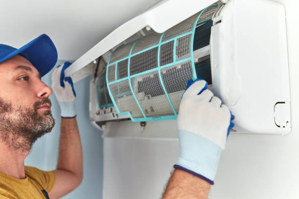istock Repairman cleaning and fixing indoors AC unit. 1404628221
