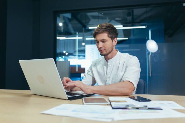 istock Serious young businessman working in the office on a laptop 1404628792