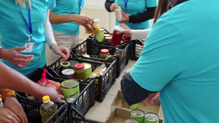 Hands placing cans and jars into donation boxes