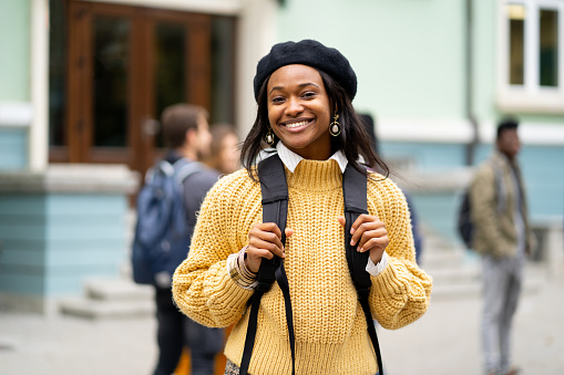 Female student smiling while going for a class in college.