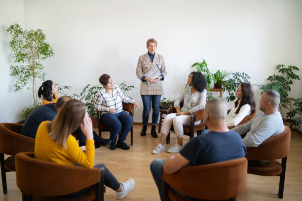 A professional woman standing in front of a group support meeting stock photo