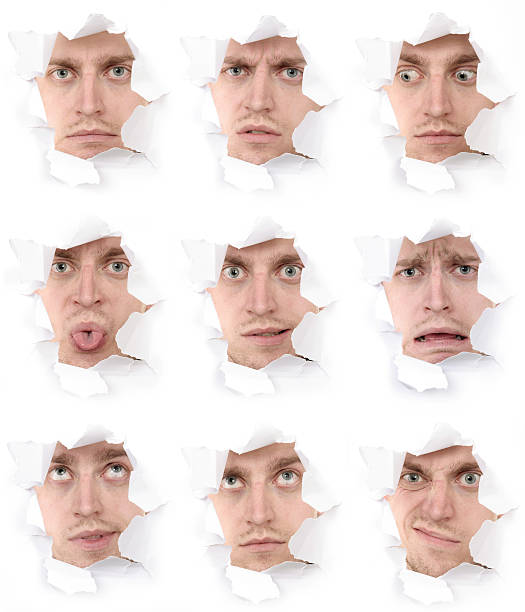 expressive faces of the emotional person in a paper hole stock photo