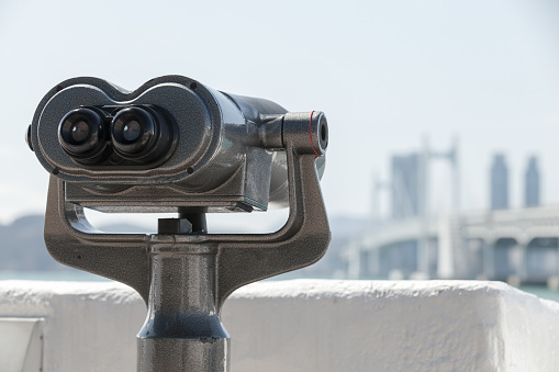 Binocular telescope for tourists mounted in the modern city, close up photo with selective focus
