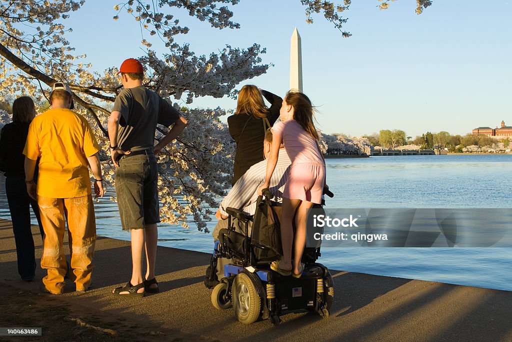 Uomo in sedia a rotelle elettrica con nipote cavalcare lungo di Washington DC - Foto stock royalty-free di Washington DC