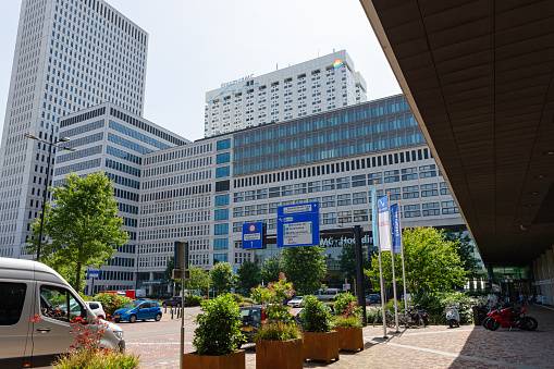 Rotterdam, South Holland, Netherlands, june 17th 2022, main entrance of the 'Erasmus University Medical Center' downtown Rotterdam on a sunny day, some people are walking on the sidewalk, cars and bicycles are parked in the area in front of the entrance - Rotterdam is the second largest Dutch city and globally known for having the largest seaport in Europe, Erasmus MC is  the largest scientific University Medical Center in Europe