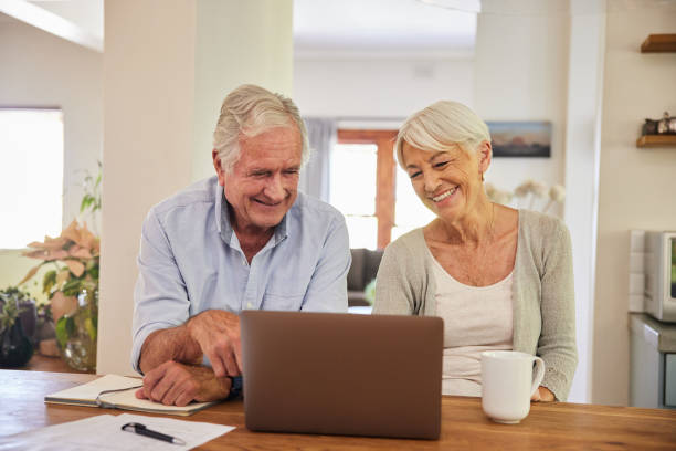 istock Senior couple laughing while doing their home finances together 1404636795