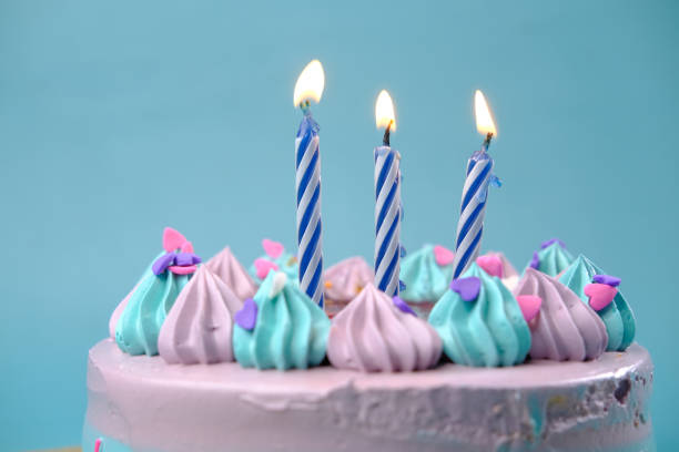 istock burning candle on a birthday cake on color background 1404636861