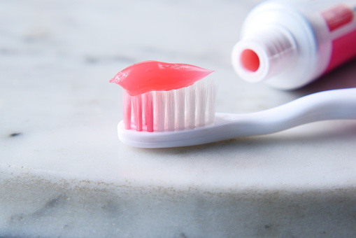 toothbrush and toothpaste on white background