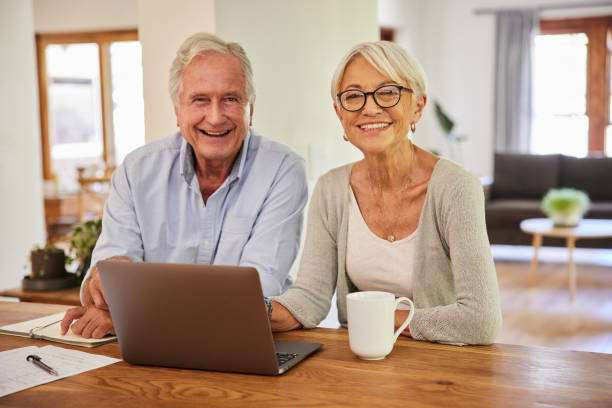 istock Smiling senior couple going over their home finances with a laptop 1404637175