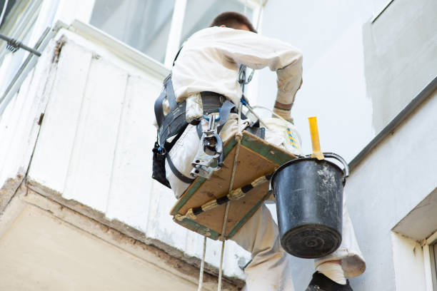 istock builder climber paints the facade of the building, close-up 1404637349