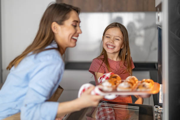 mãe e filha havig diversão na cozinha - baking cake making women - fotografias e filmes do acervo