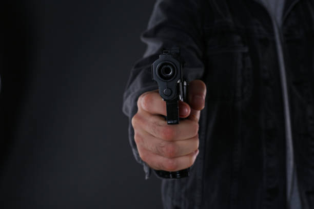 istock Man holding gun on black background, closeup 1404639329