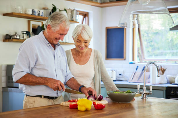 istock Senior couple laughing while preparing a healthy lunch in their kitchen 1404639431
