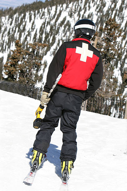 Ski Patrol with Drill A ski patrol member carries a large drill to setup warning signs at a popular resort ski patrol photos stock pictures, royalty-free photos & images