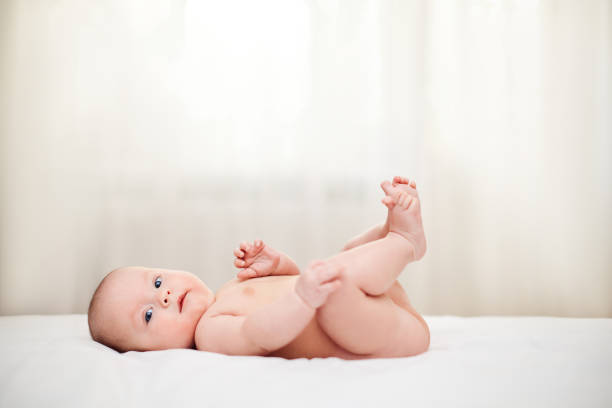 istock Cute little baby in diaper on bed. 1404640484