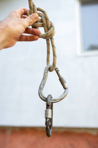 istock builder climber holds a safety carabiner in his hand, close-up 1404641283