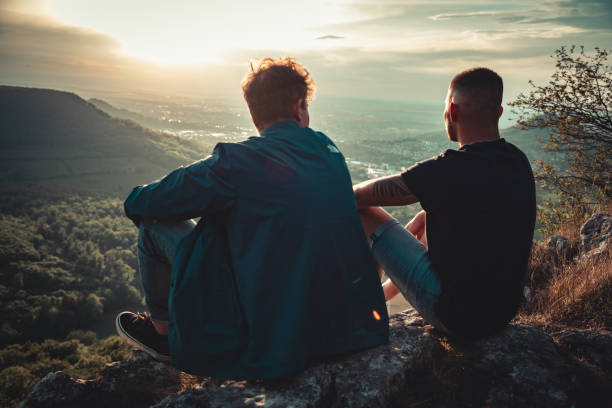 istock Best Friends Enjoying the Valley View from Mountain Top Watching Sunset 1404642236