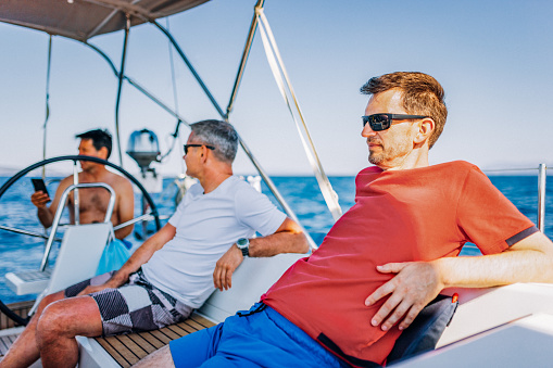 Crew members enjoying sailing while having conversation.