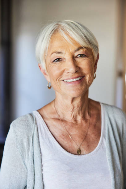 istock Senior woman smiling while standing in her living room 1404643280
