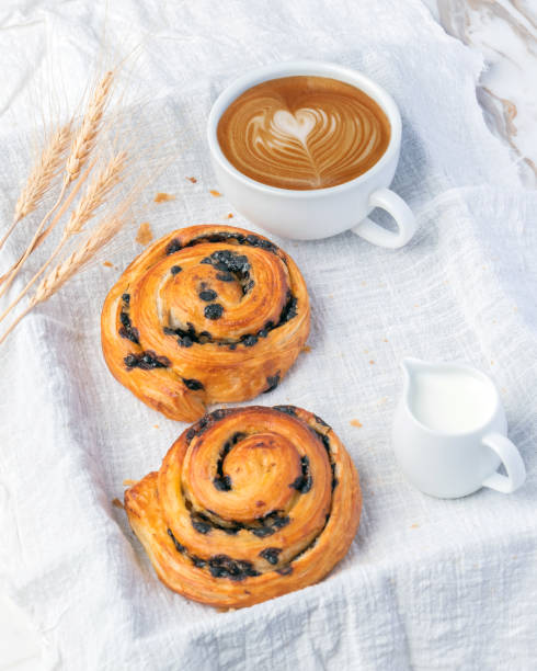 istock Fresh Danish bread with a coffee mug on white fabric. 1404644067