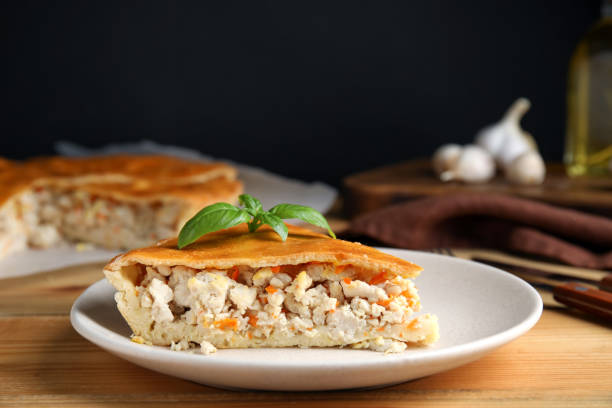 istock Slice of delicious meat pie with basil on wooden table, space for text 1404644441