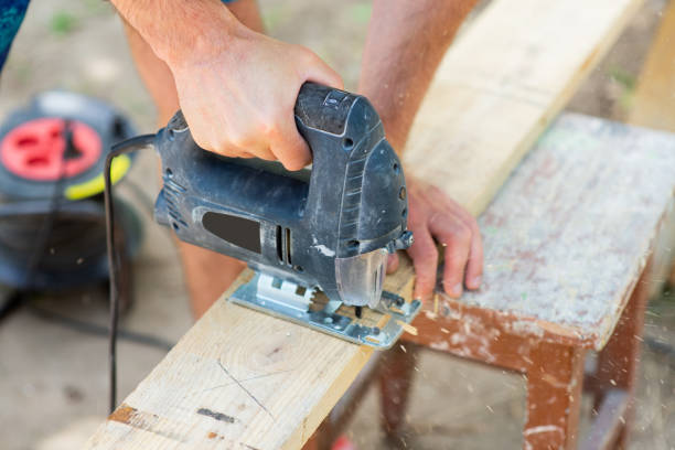 istock A male carpenter cuts a wooden plank with a jigsaw, close-up 1404644597