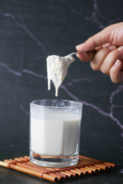 whole cream taking from a glass of milk