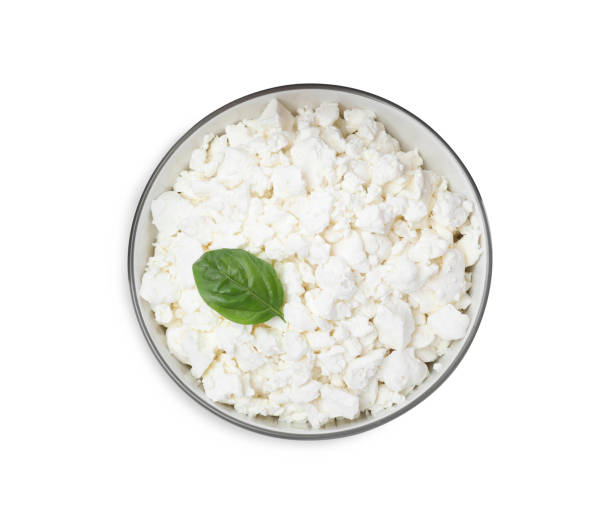 istock Fresh cottage cheese with basil in bowl isolated on white, top view 1404645632