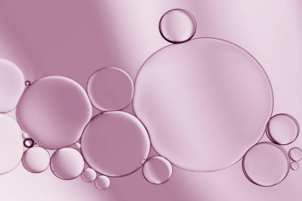 istock Oil droplets on water surface  created bubbles and an art image on pale purple  light effects background. 1404646149