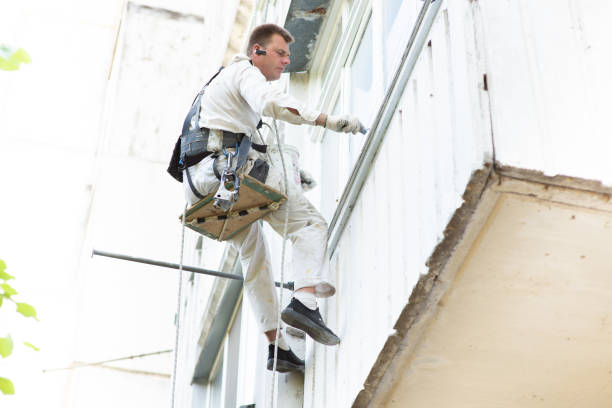 istock climber-builder paints the building in a light color, at a height, 1404646933