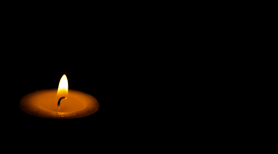 Candle light isolated on black background.