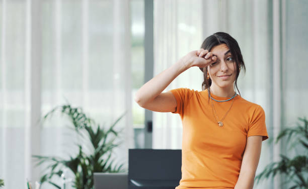 mujer joven frotándose los ojos - frotarse los ojos fotografías e imágenes de stock