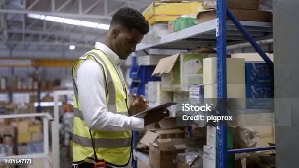 Black Worker Is Checking The Goods In The Warehouse Stock Photo - Download Image Now