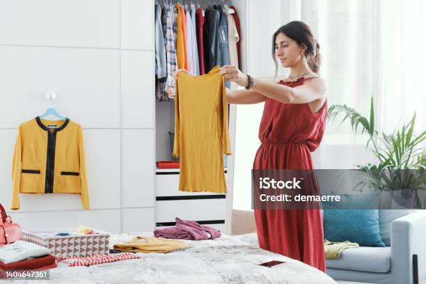 Woman Choosing Clothes In Her Bedroom Stock Photo - Download Image Now - Closet, Decluttering, One Woman Only