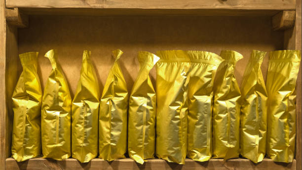 istock Gold blank plastic vacuum sealed coffee bags on shelf. 1404647581