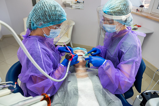 Doctor teaching medical students how to attend a newborn baby after labor using a dummy - healthcare and medicine concepts