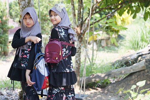 Asian muslim girls wearing hijab and backpack in her house