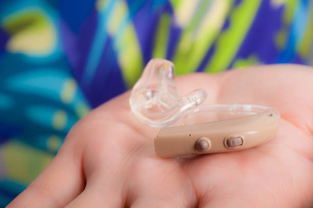 istock senior person holding hearing aid closeup 1404649128
