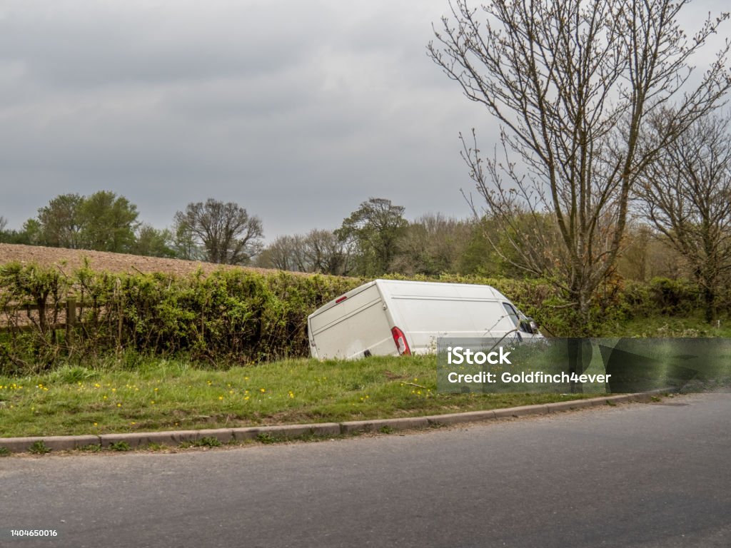 Unidentifiable white van in ditch, abandoned. Unidentifiable white van in ditch, abandoned by driver. UK. Van - Vehicle Stock Photo