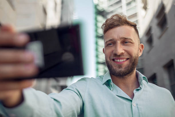 istock Cheerful businessman using phone and taking a selfie 1404650644