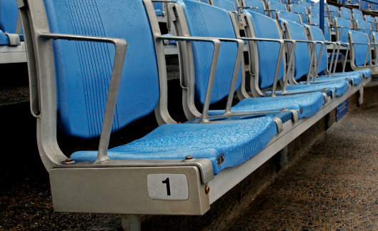 close-up of front row stadium seats starting with seat number one.