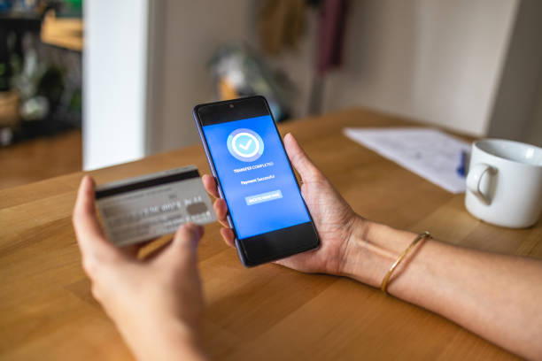 istock Young woman Paying Bills with mobile phone 1404652392