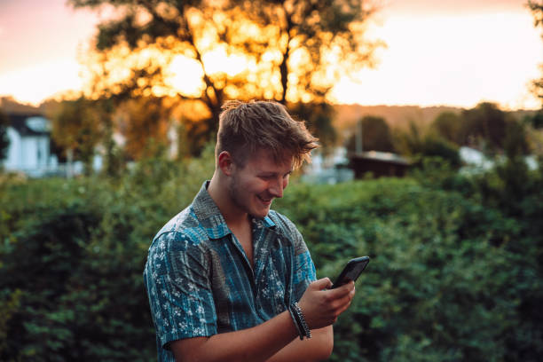 istock LOL Young Man Outdoors Checking Funny Messages On Mobile Phone 1404655102