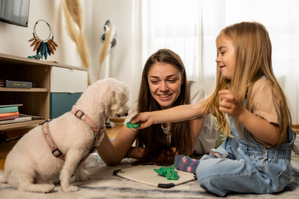 istock Mother and daughter playing with a dog 1404655113